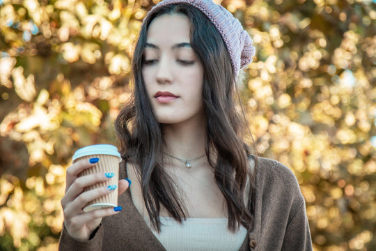 young girl with coffee cup on autumn background