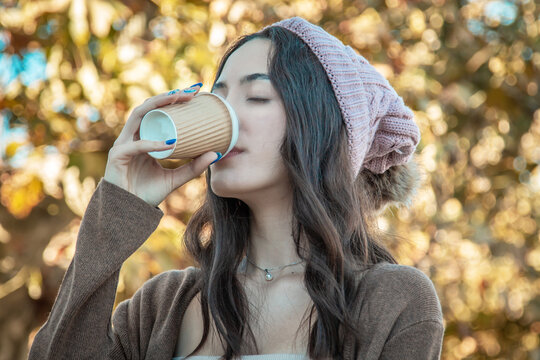 relaxed young girl with coffee in autumn park