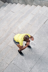 Top view of sportsman doing squats on stairs outside