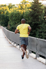 Obraz premium Unrecognizable man jogging on sidewalk in the city outdoors