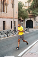 Sportsman jogging on street in the city at day