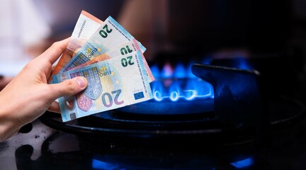 Fototapeta premium Euro banknotes in denominations of 10 and 20 eur against the background of a gas stove. A drastic increase in gas and heating prices. Energy crisis in Europe