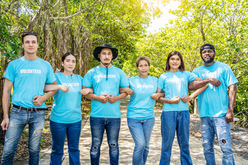 Portrait of smiling male and female volunteers standing with arms around. Multiracial group of...