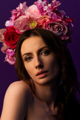 Portrait of an attractive young Ukrainian woman wearing a beautiful wreath of pink roses. Headdress for a girl. Concept wedding style or beauty salon and skin care.