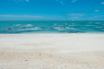Fototapeta na wymiar Wide and empty white sandy beach and seaside in sunny weather
