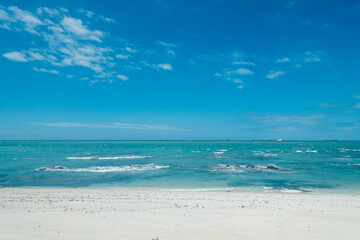 Fototapeta na wymiar Wide and empty white sandy beach and seaside in sunny weather