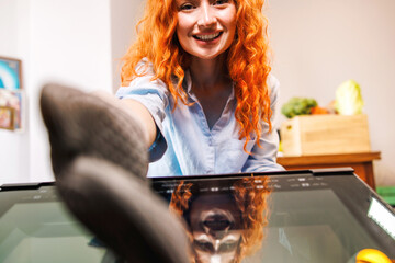 The cheerful housewife reaches out to take the tasty pie out of the oven with a big smile on her face.