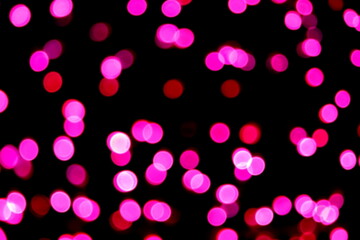 Many soft purple and red blurry bokeh light on dark background in Christmas and New Year festival day, can use for background