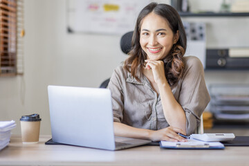 Fototapeta premium Young Asian businesswoman attending a virtual working financial report analysis Business Documents in workplace an home office, asian woman working contract.