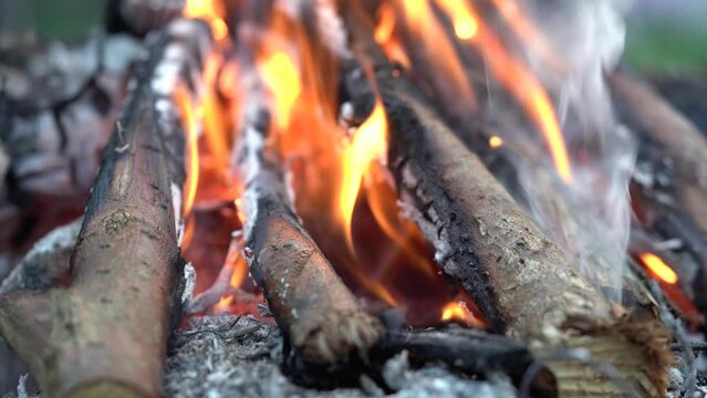 Detail view of fire burning in fireplace outside.