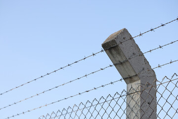 Fototapeta premium Barbed wire and blue sky in background