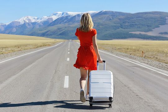 girl walking on the highway with luggage, suitcase travel view from the back, landscape america, hitchhiking concept