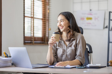 Fototapeta na wymiar Happy indian girl asian woman drinking hot coffee in workplace an home office.