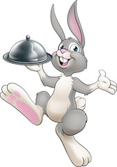Obraz na płótnie Canvas An Easter bunny rabbit cartoon character, possibly the chef, serving or delivering food from a restaurant in a silver cloche tray plate or platter.