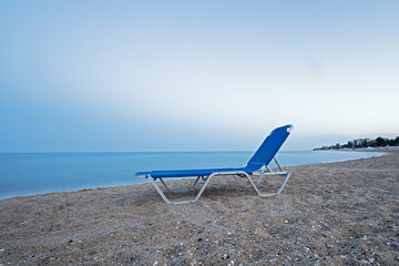 unused blue lounge chair on the beach