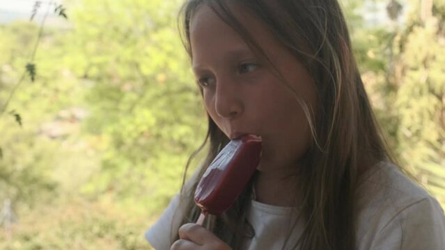 a girl eats a popsicle