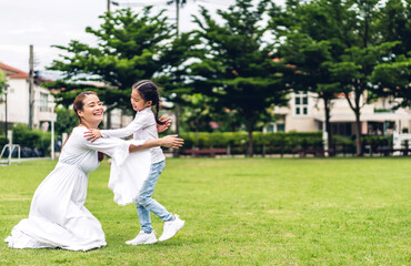 Portrait of enjoy happy love asian family mother holding hug cute little asian girl child smiling play and having fun moments good time in summer park at home