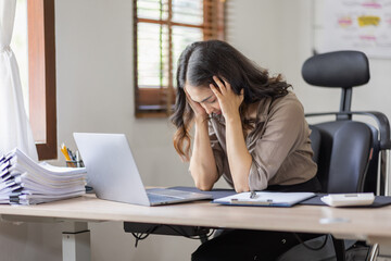 Asian indian women are stressed while working on laptop, Tired asian businesswoman with headache at office, feeling sick at work copy space in workplace an home office.