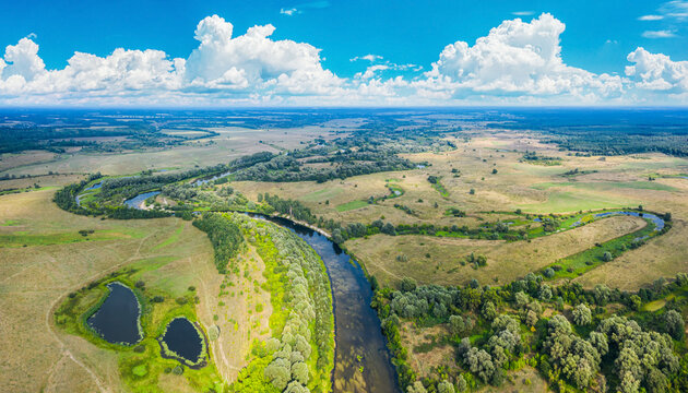 Beautiful Ukrainian nature background. Drone view on riverbank of the Seym river and amazing cloudscape over it. Summertime.
