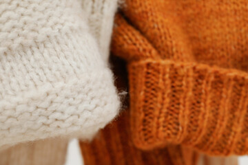 Fototapeta na wymiar Hanging sweaters, concept of autumn season clothes