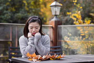 Sad tired Asian woman lonely at outdoor cafe during self isolation quarantine for COVID-19...