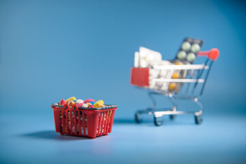 Buy medicine. Shopping basket with various medicinal, pills, tablets on blue background. Studio Photo