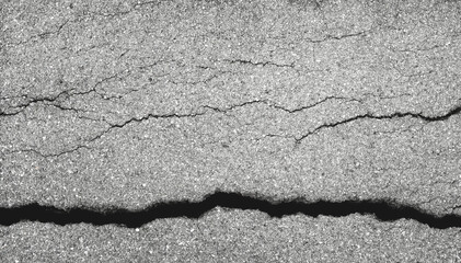 Obraz premium Earthquake disaster background. Cracks of road surface. Broken concrete backdrop. Asphalt pavement damage.