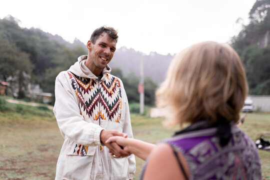 Young man with female shaman greeting each other in nature