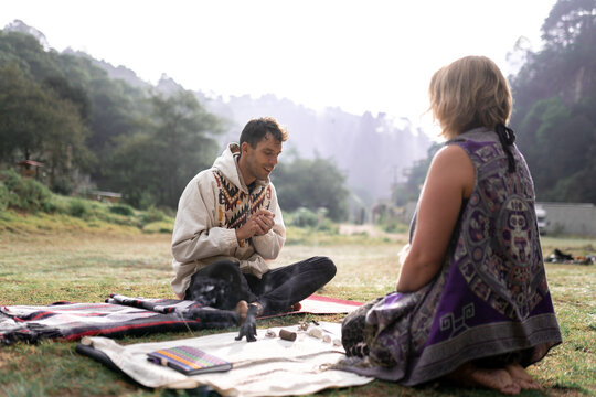 Tranquil Woman And Man Preparing For Shamanic Healing Procedure In Nature