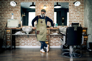 Mature male barber in barbershop