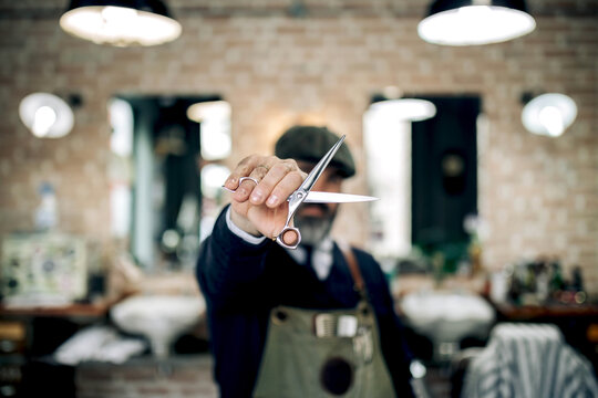 Barber with scissors in barbershop