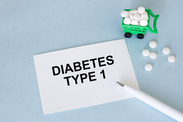 White sticker with text Diabetes type 1 on a blue background next to pen and tablet, medical concept