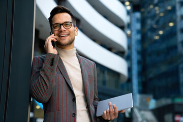 Portrait of successful man with mobile in urban background. Business technology device concept