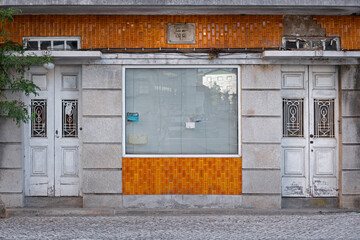 Ancienne boutique abandonnée en mosaïque orange dans un quartier défavorisé d'une ville du Portugal. © fred.do.photo