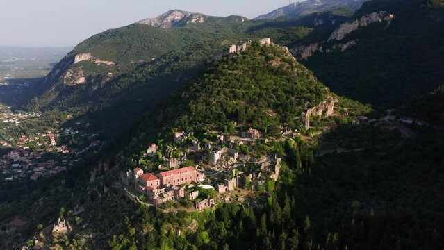 Drone shot of medieval old city of Mystras with Monastery of Pantanassa, Temple of Agia Sofia and uphill castle of Mystras, Sparta, Peloponnese, Greece