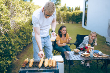 Happy family cheering with barbecue dinner outdoor - Group of people having fun at weekend meal - BBQ Food, taste and summer concept, Man cooking meat on barbecue grill at summer party