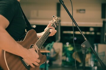 Closeup shot of a man playing an acoustic guitar