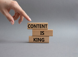 Content is king symbol. Concept words Content is king on wooden blocks. Beautiful grey background. Businessman hand. Business and Content is king concept. Copy space.