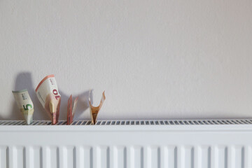 Home heating expenses and savings concept. Money on heating radiator.	