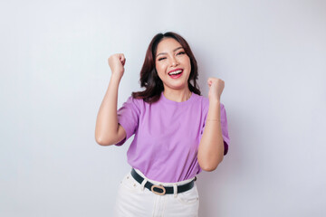 Obraz na płótnie Canvas A young Asian woman with a happy successful expression wearing lilac purple shirt isolated by white background