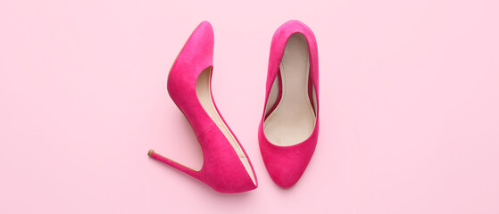 Stylish high-heeled shoes on pink background, top view