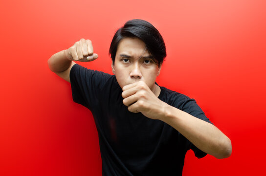 Asian man wearing black tshirt over isolated background ready for fight. asian man with angry expression threatening and looking for fight.