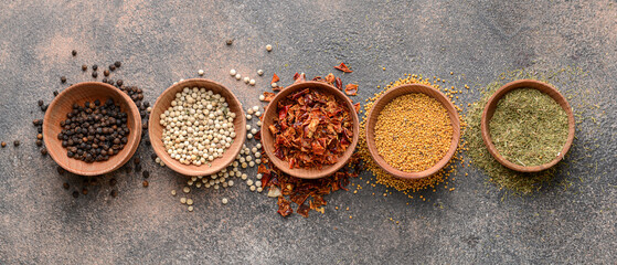 Bowls with different spices on grey background, top view