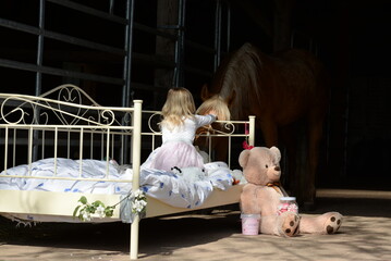 Kinderzimmer im Pferdestall. Süßes Kind mit Traumpferd