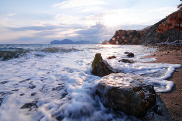 Dramatic landscape with sea shore, waves and stones on the stones beach.