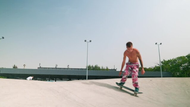 A young skateboarder rides a skateboard in the park on the railing and on the mountains on the concrete. Jumps over obstacles 