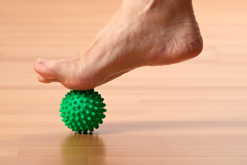 Massage der Fußreflexzonen mit dem Igelball - 531886026