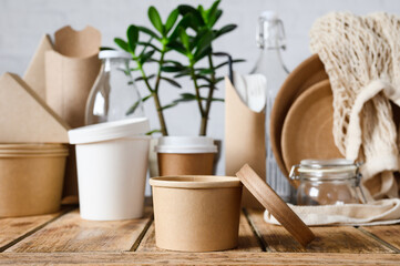 Round paper container for food on the background of paper utensils. The concept of zero waste.