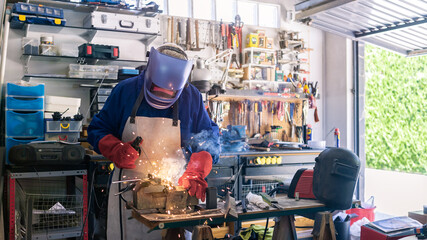 Metal processing with a man using welding machine for steel seam. Special clothe