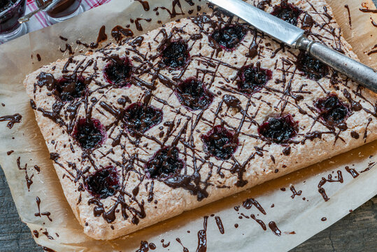 Coconut and blackcurrant jam macaroon traybake with chocolate drizzle